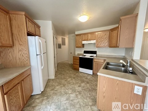 A kitchen with wooden cabinets and a white refrigerator.