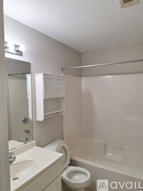 A white bathroom with a toilet, sink, and bathtub.