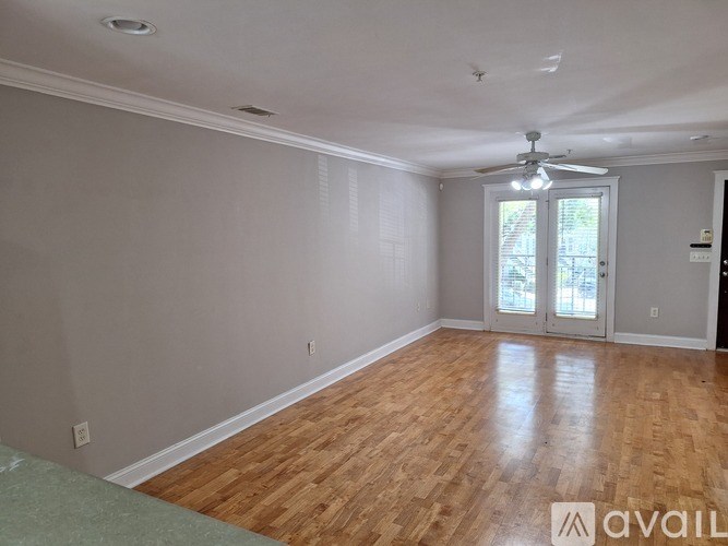 A room with wooden floors and a ceiling fan.