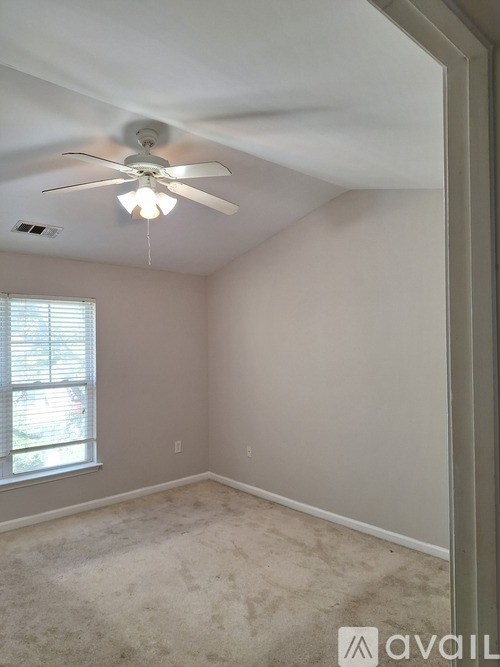 A room with a ceiling fan and a window.