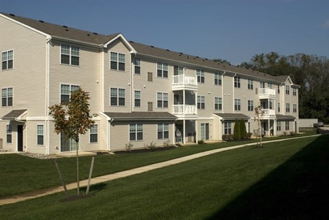 a large apartment building on the side of a green lawn