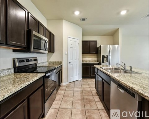 A kitchen with brown cabinets and a white door in the middle.