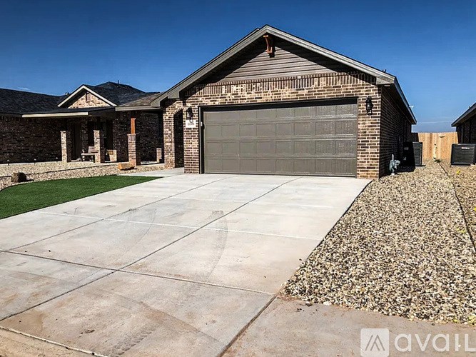A house with a garage and driveway in front.