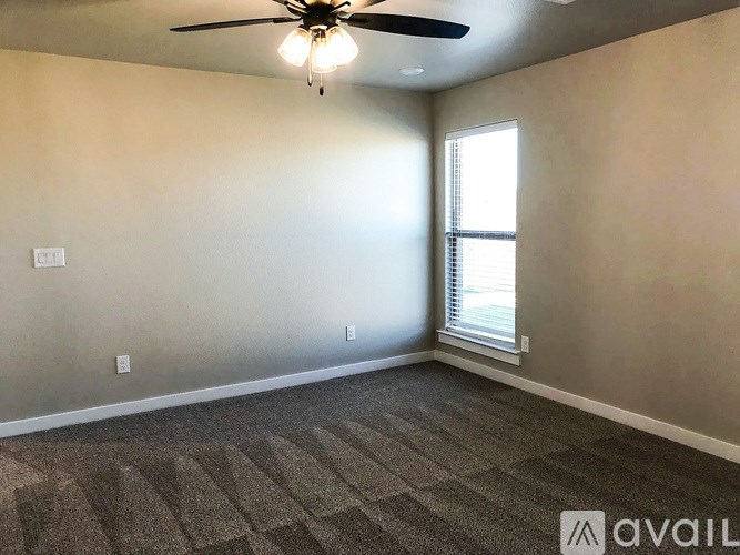 A room with a ceiling fan and carpeted floor.