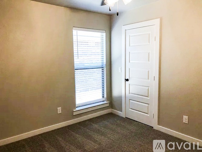 A room with a door, window, and carpeted floor.