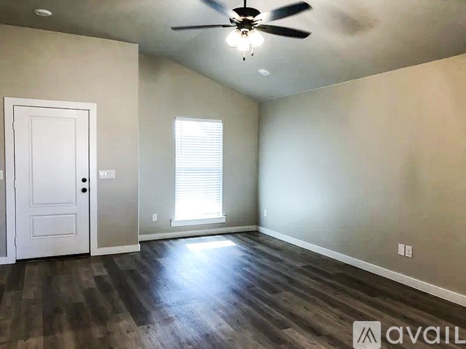 A room with a ceiling fan and a door.