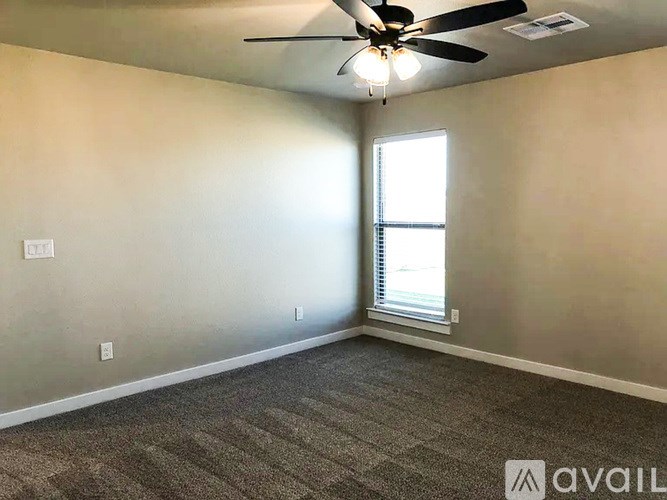A room with a ceiling fan and carpeted floor.