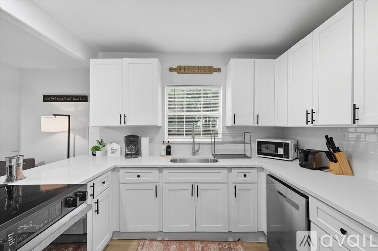 A kitchen with white cabinets and a black stove top.