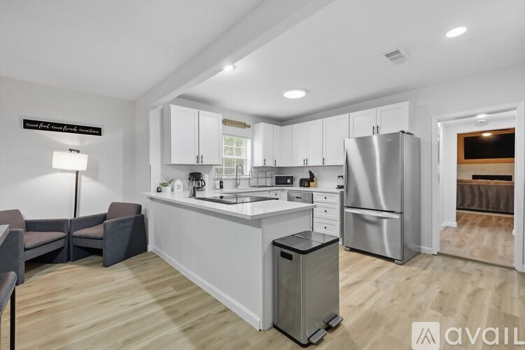A kitchen with white cabinets and a stainless steel refrigerator.
