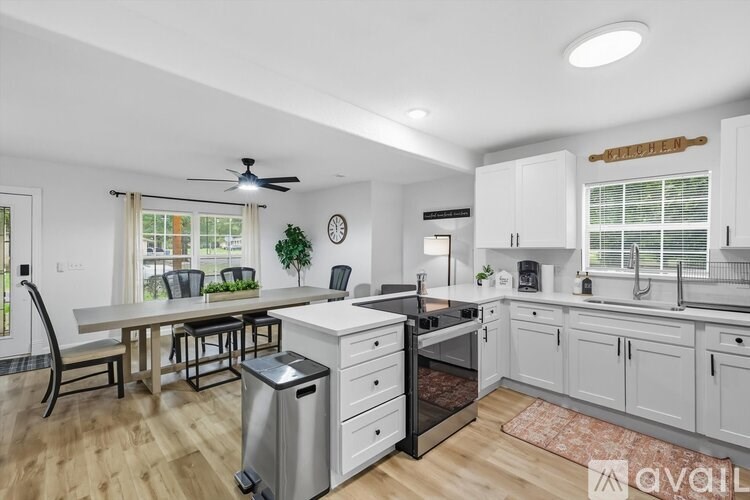 A kitchen with white cabinets and a wooden floor.