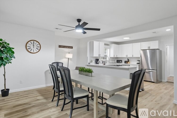A kitchen with a table and chairs in front of it.