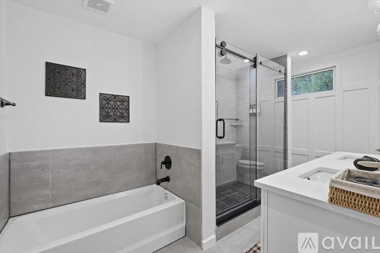 A bathroom with a white tub and a walk-in shower.