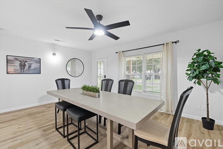 A dining room with a table, chairs, and a ceiling fan.
