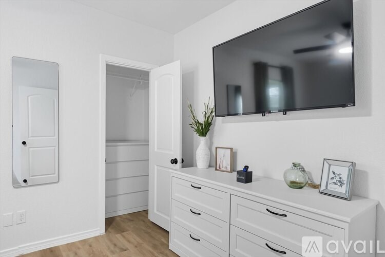 A white bathroom with a vanity and a large mirror.