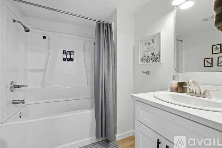 A white bathroom with a glass shower door and a white sink.