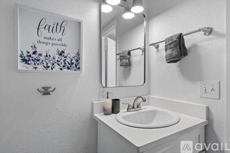 A bathroom with a white sink and a mirror.