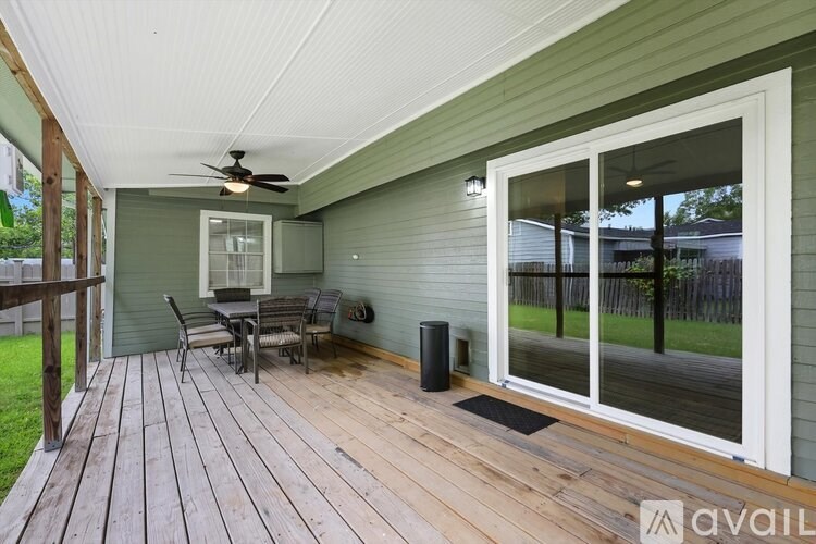 A deck with a table and chairs is on the patio of a house.