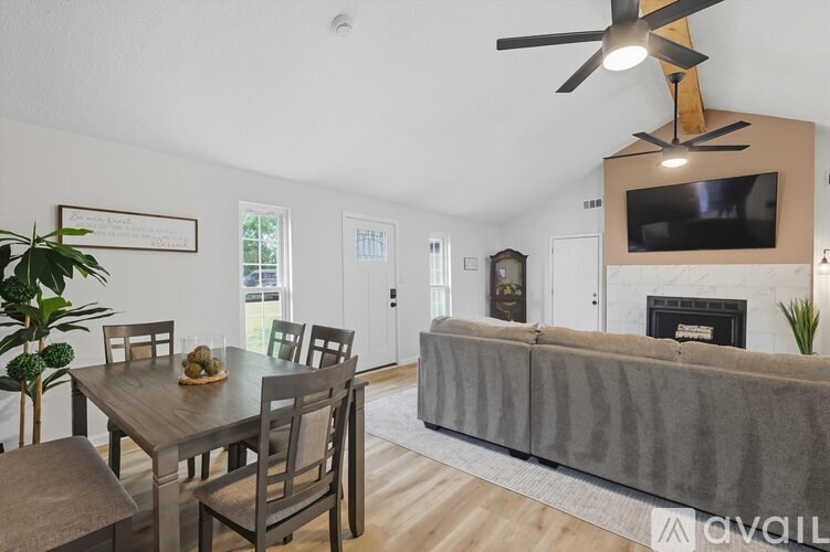 A modern living room with a grey couch and a wooden dining table.