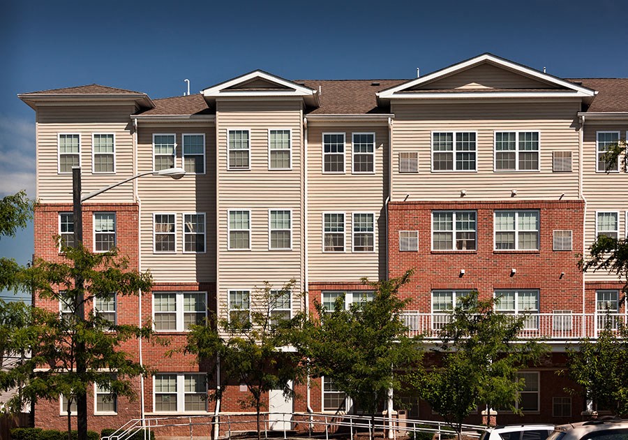 a large apartment building with red brick and tan siding
