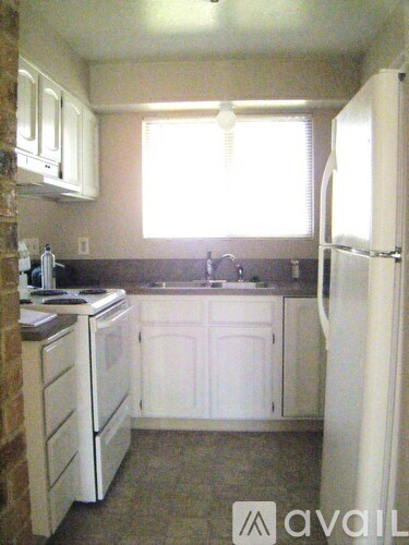 A kitchen with white appliances and cabinets.