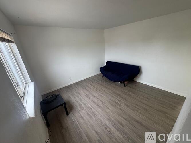A room with a blue couch and a black table.