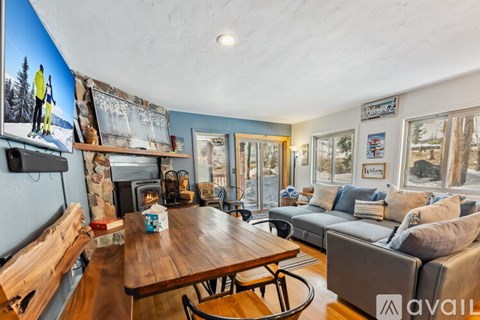 A living room with a wooden table and a fireplace.