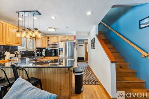 A kitchen with wooden cabinets and a blue wall.