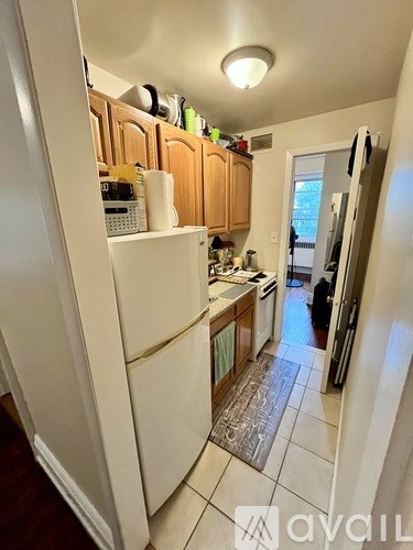 A kitchen with a white refrigerator and wooden cabinets.