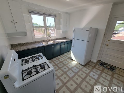 A kitchen with a white gas stove and a white fridge.