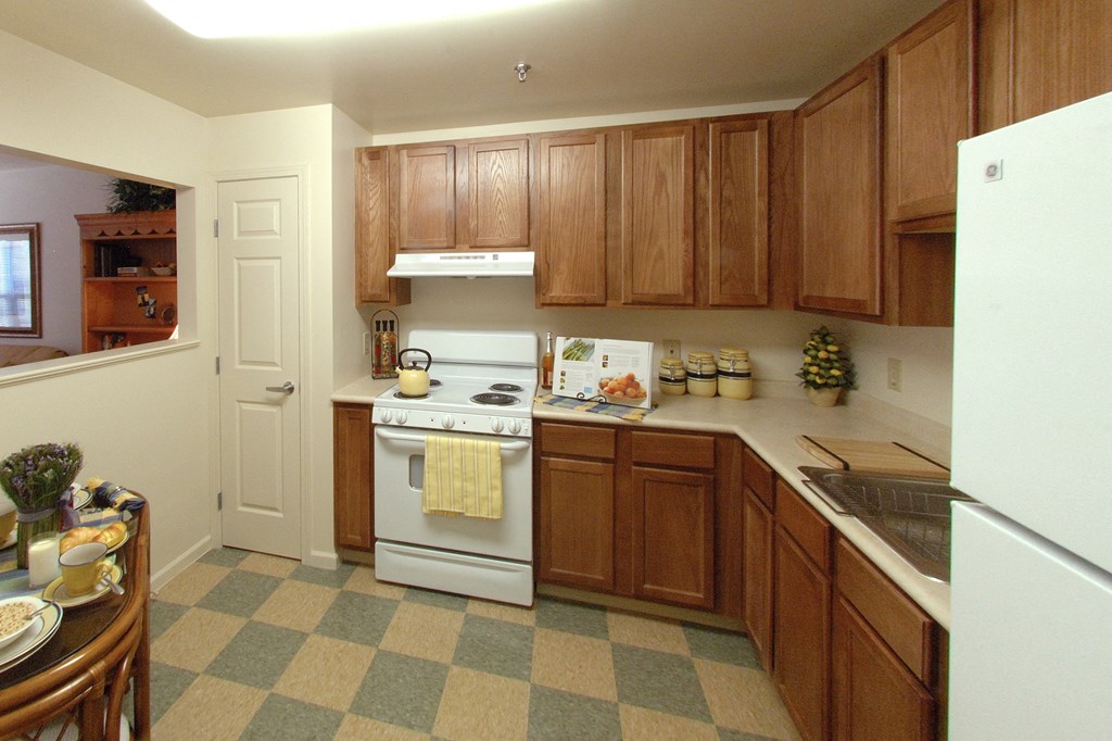 a kitchen with wooden cabinets and a white stove
