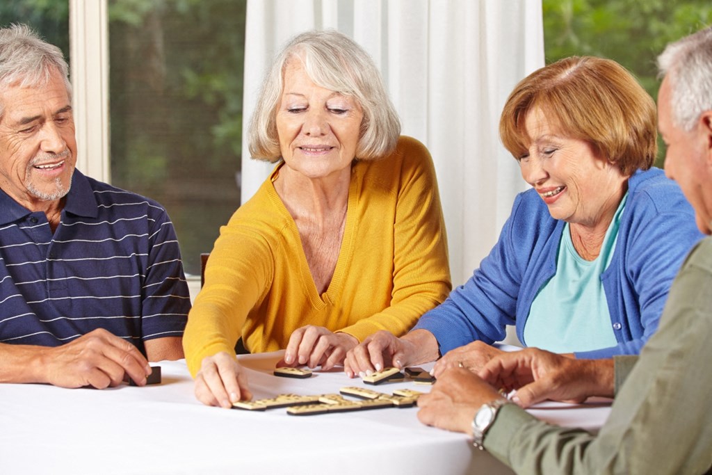a group of people sitting at a table playing cards