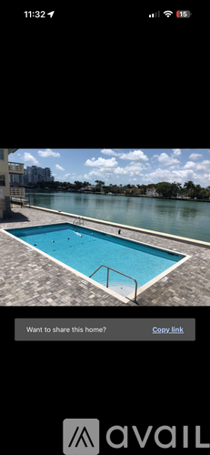 A rectangular blue pool with a metal railing on the side.