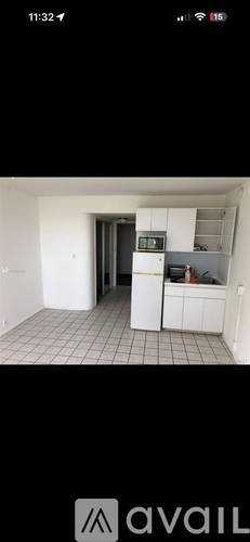 A kitchen with white cabinets and a black refrigerator.