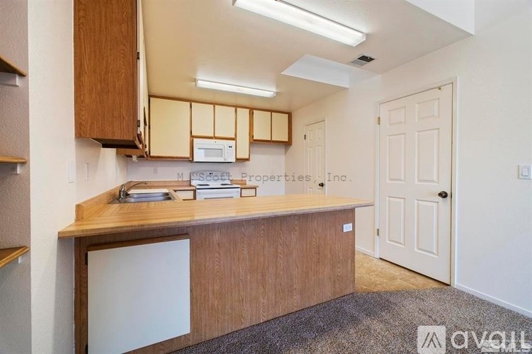 A kitchen area with wooden cabinets and a countertop.