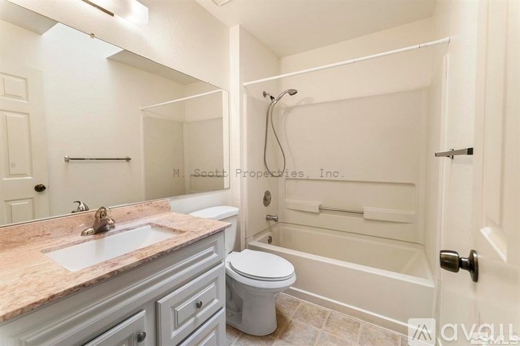 A bathroom with a marble countertop and a toilet.