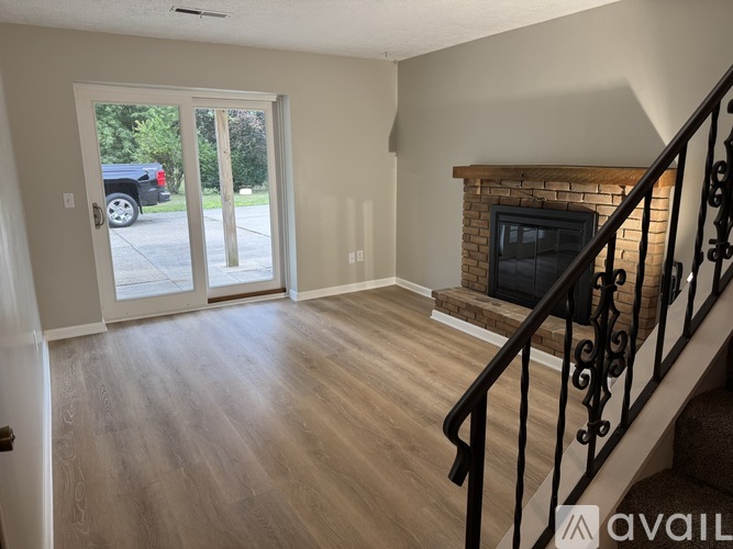 A living room with a fireplace and a staircase.