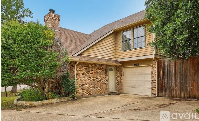 A house with a garage and a stone wall.