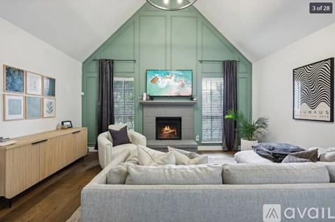 A living room with a grey couch and a fireplace.