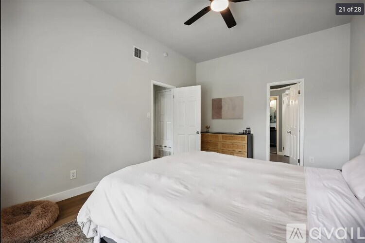 A bedroom with a large bed and a ceiling fan.