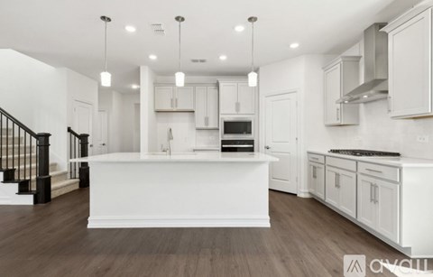 A modern kitchen with white cabinets and a central island.