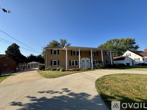 A house with a driveway in front of it and a sign that says "available".