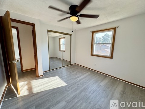 A room with a ceiling fan and a large mirror on the wall.