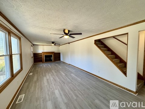 A spacious room with a staircase leading to another level.