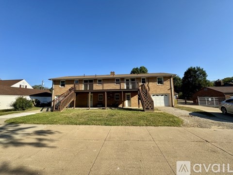 A two-story house with a garage and a driveway in front.