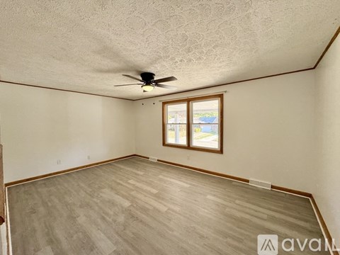 A room with a ceiling fan and a window.
