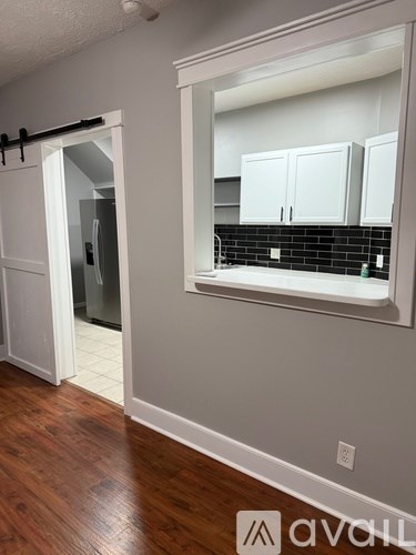 A white house with a black iron fence and a black door.