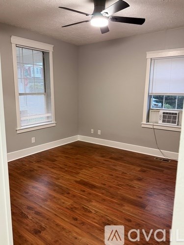 A room with wooden flooring and a ceiling fan.