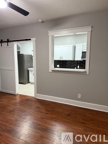 A room with a wooden floor and a window.