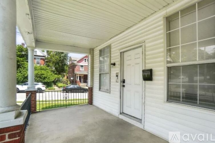 A white house with a black gate and a white door.