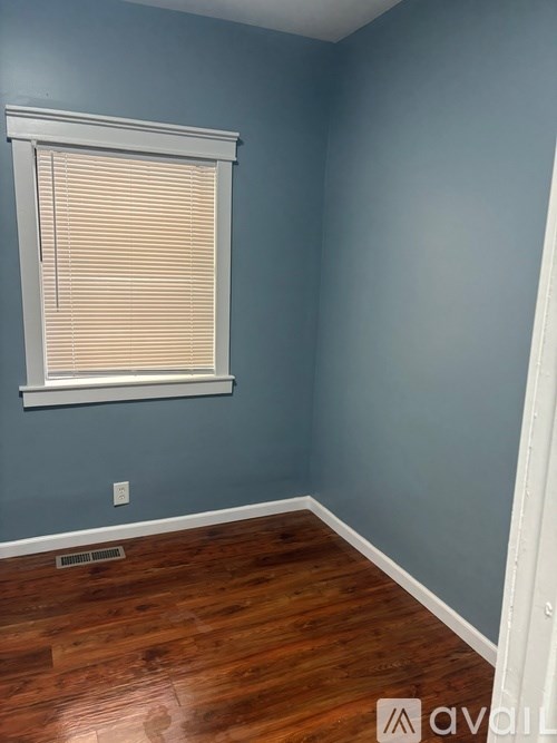 A room with a window and wooden flooring.